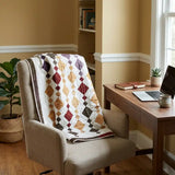 Embers at Dusk lap quilt draped over a home office chair