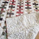 Handmade Chic Holiday throw with corner flipped up to show backing with quilt top