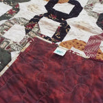 Corner flipped over to show backing for Fireside Links Lap Quilt.