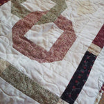 Detail of Fireside Links Lap Quilt showing stitching, pieced border, and binding.