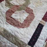 Detail of Fireside Links Lap Quilt showing stitching, pieced border, and binding.