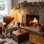 Fireside Links Lap Quilt shown over a leather chair near a stone fireplace in a classically decorated living room.