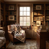 Fireside Links Lap Quilt shown draped over a brown leather chair in a traditional study.