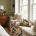 Fireside Links Lap Quilt shown on a window seat in a neutrally designed bedroom.