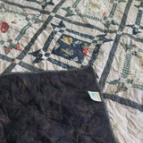 Framed Botanicals Twin Quilt shown with corner flipped over to show backing.