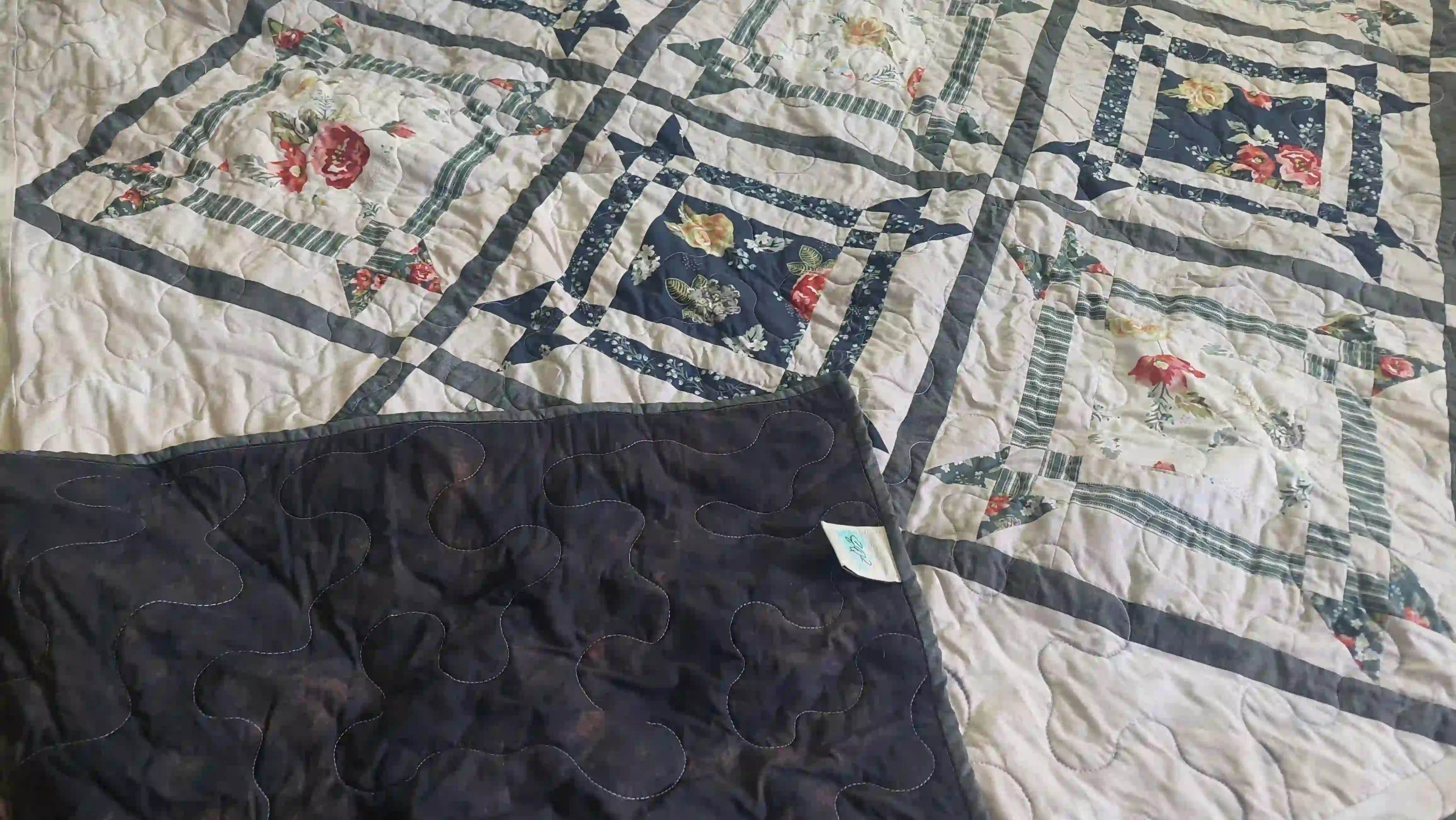 Framed Botanicals Twin Quilt shown with corner flipped over to show backing.