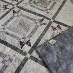 Gathered Correspondence Twin Quilt shown with corner flipped over to see backing.