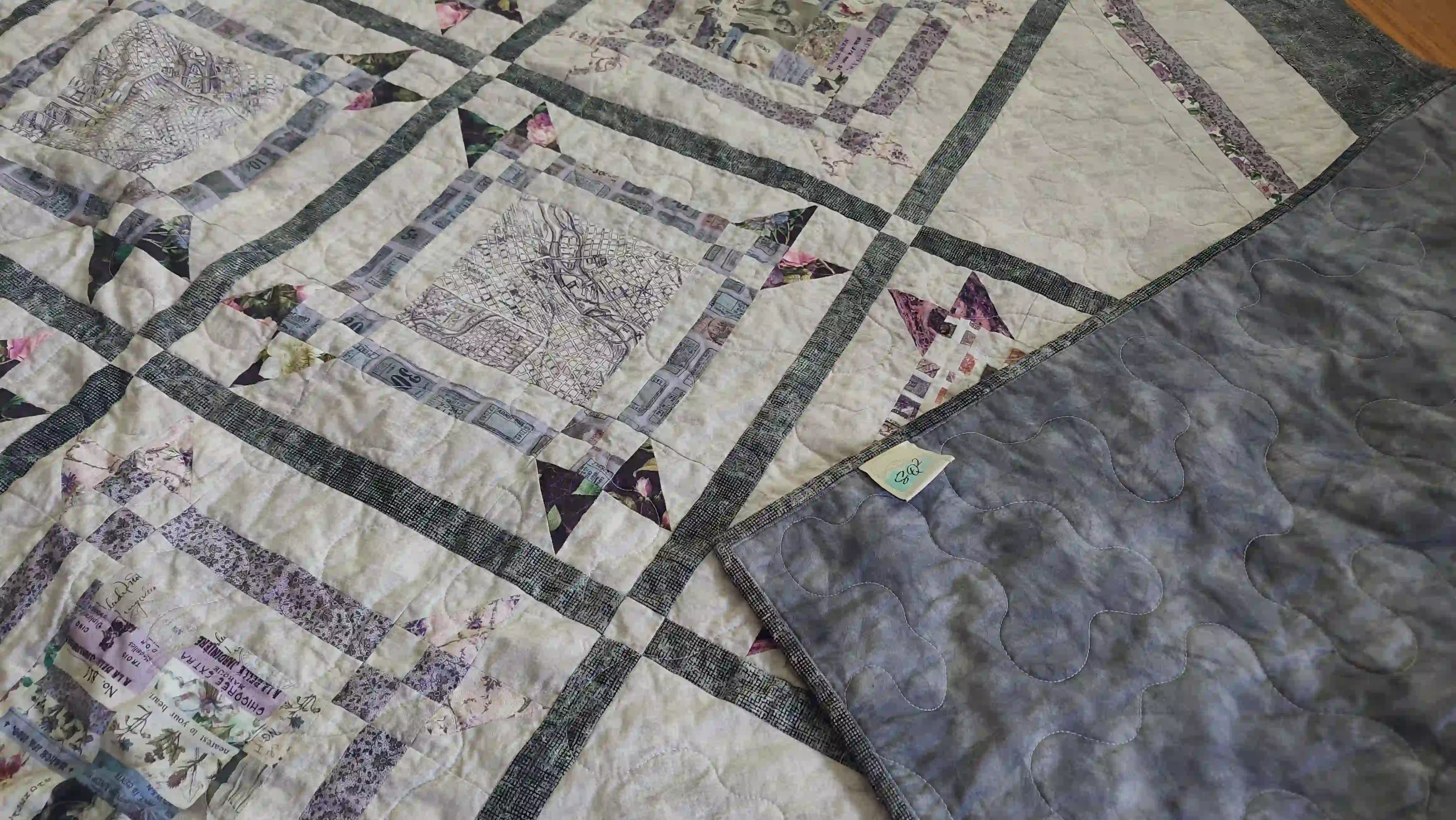Gathered Correspondence Twin Quilt shown with corner flipped over to see backing.