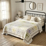 Georgina Garden on a queen size bed in a neutral bedroom with a black iron bed frame and wooden floors