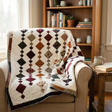 Holiday Heirloom lap quilt shown draped over a chair in a reading nook