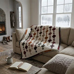 Holiday Heirloom lap quilt shown draped over a sectional