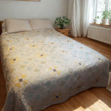 Lightweight cotton queen quilt in aqua floral and honey tones styled in a modern minimalist bedroom