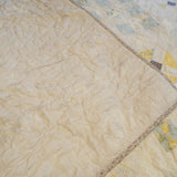 Folded corner showing fabric patterns and cotton backing of the Honeybloom queen quilt