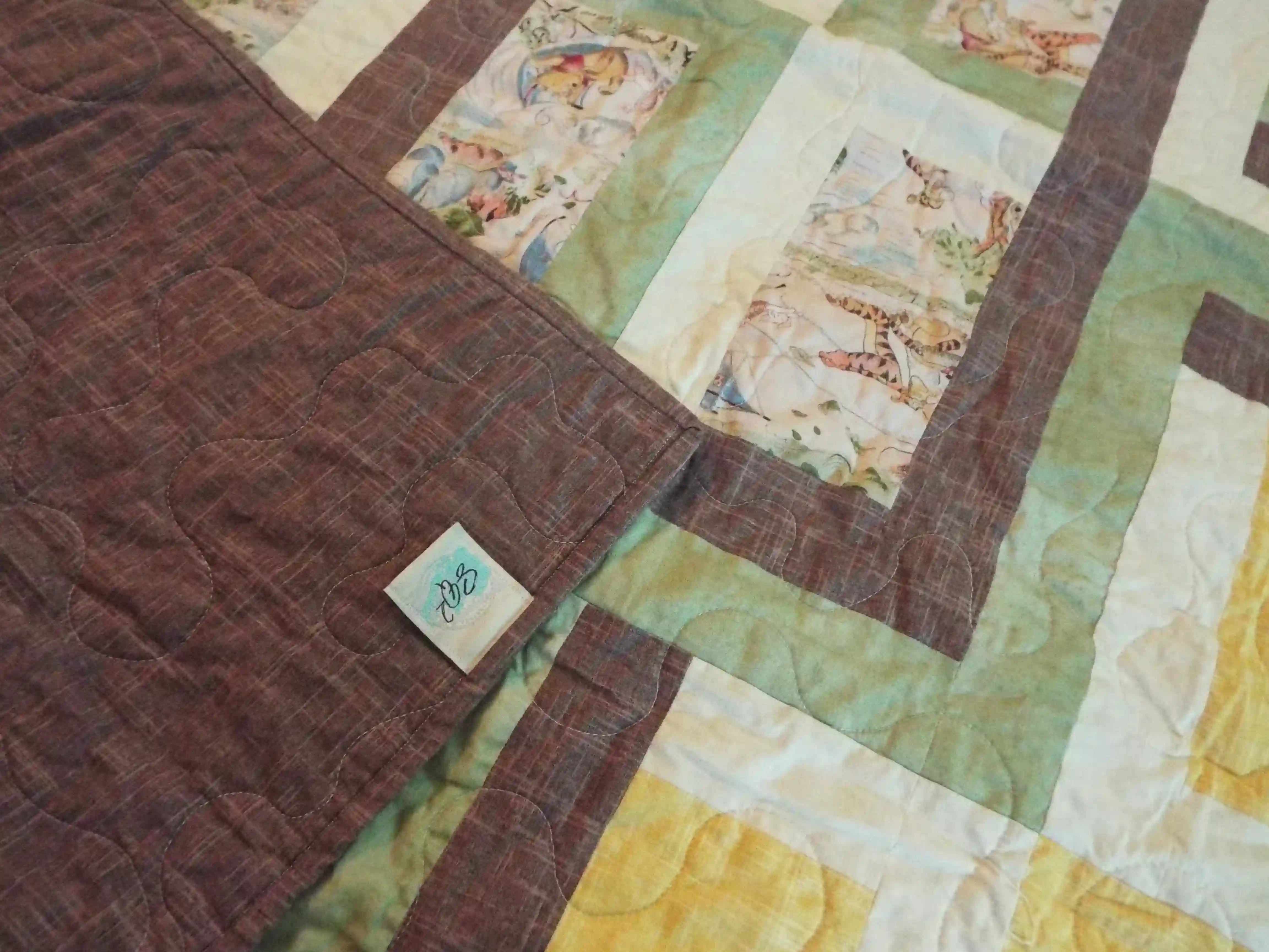 Corner flipped up on Honeyed Tails Baby Quilt to show backing detail.
