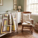 Honeyed Tails shown draped over a white crib in a pale green nursery.