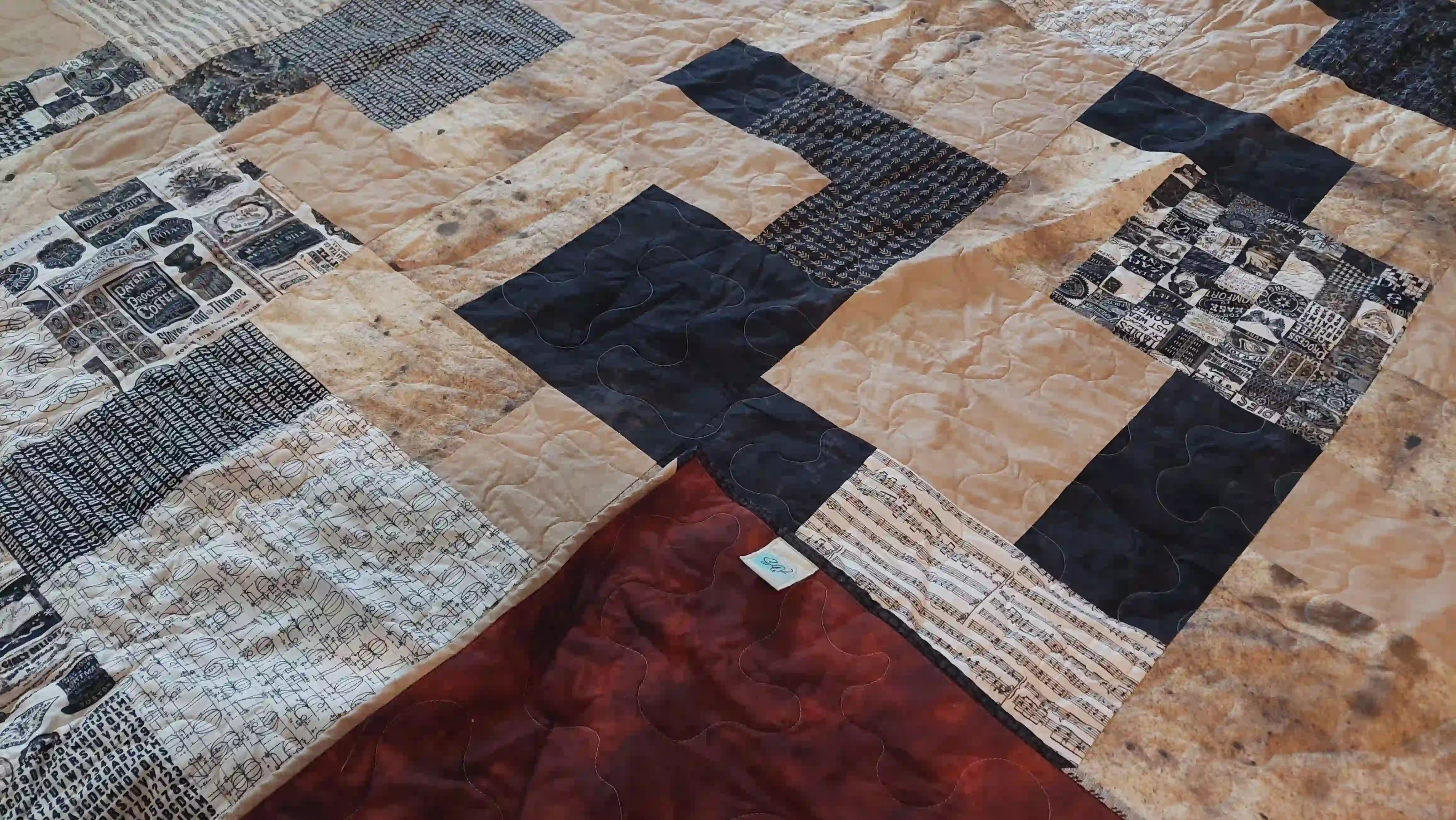 Inkstone King quilt shown with corner flipped up to see backing against quilt top.