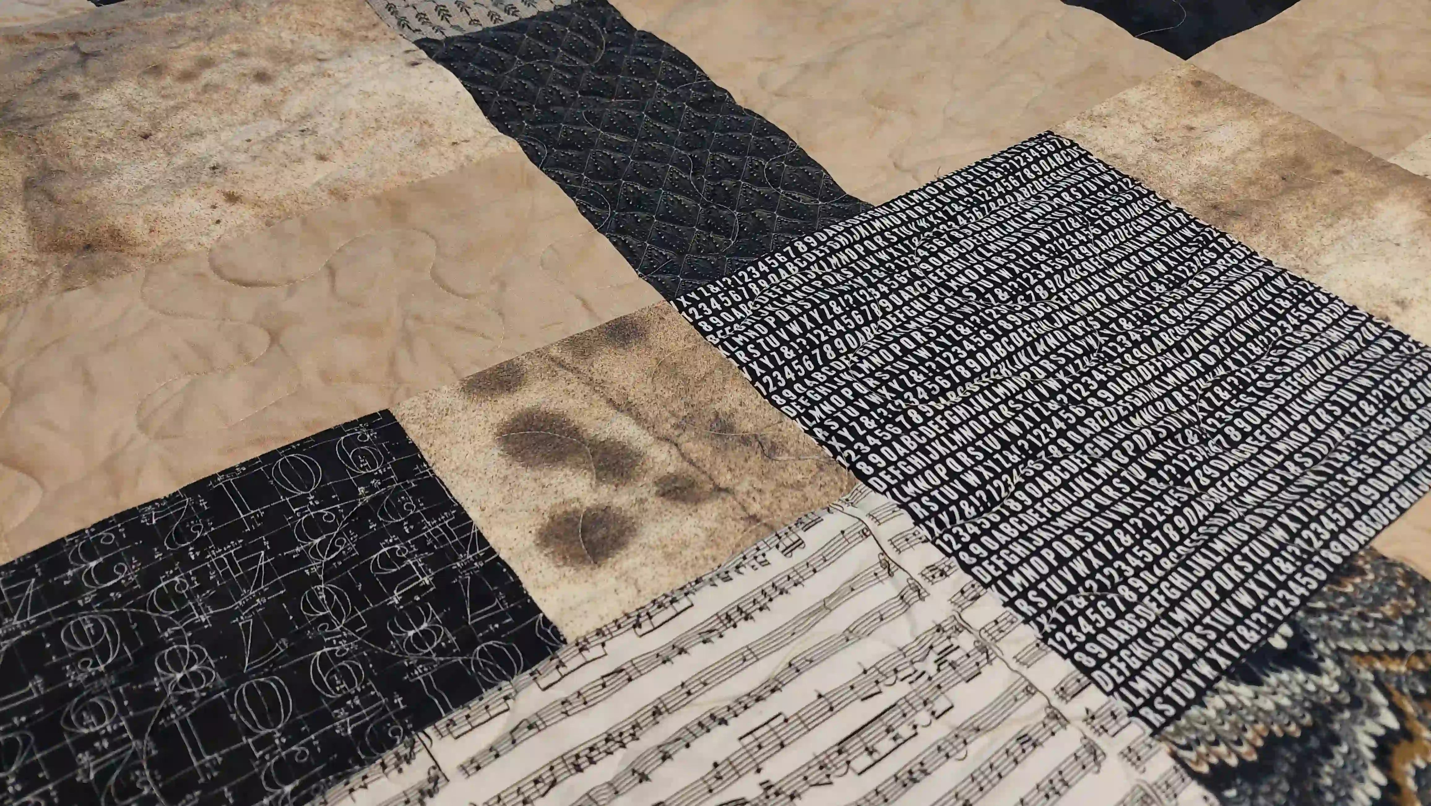Close up of Inkstone King quilt showing fabrics and stitching detail.