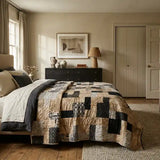 Inkstone King quilt shown in a sophisticated bedroom with black dresser and neutral walls.
