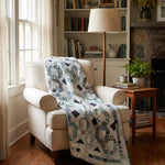 Links to the Past Lap Quilt shown in a corner reading nook of a living room with a stone fireplace and built in bookshelves.