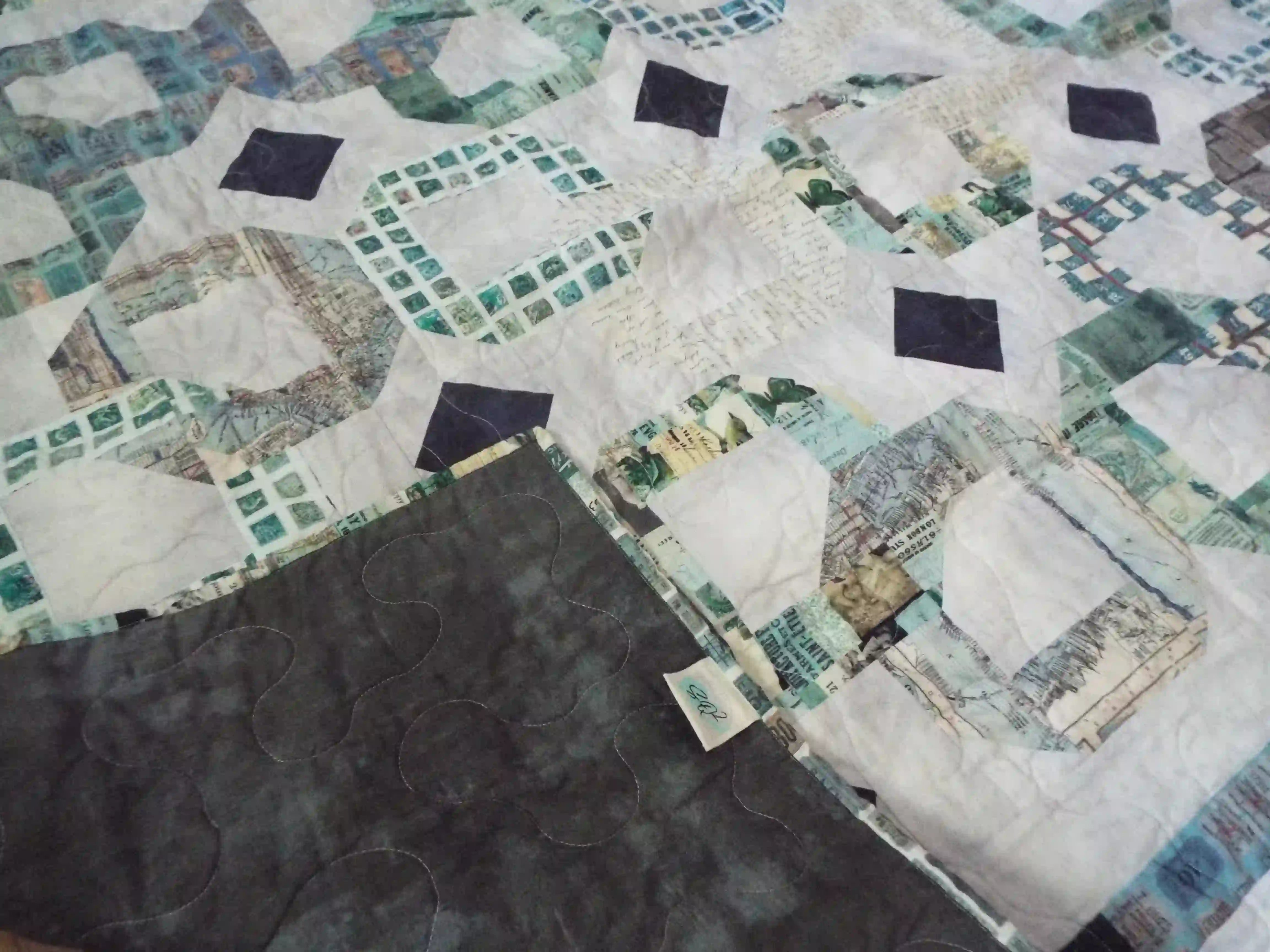 Corner flipped up for Links to the Past Lap Quilt showing backing.