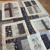 Angled lay of Little Framework Baby Quilt showing closer look at fabrics.