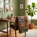 Marine Eagle Handmade Throw Quilt is draped over a wooden chair in a styled home office setting with a desk, lamp, and a large fiddle-leaf fig plant.