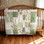 Handmade green baby quilt draped over wooden crib with warm-toned nursery and wood floors