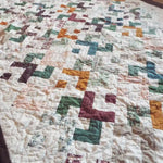 Angled lay of quilt showing stitching and piecing detail