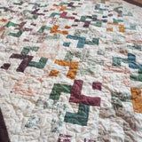 Angled lay of quilt showing stitching and piecing detail