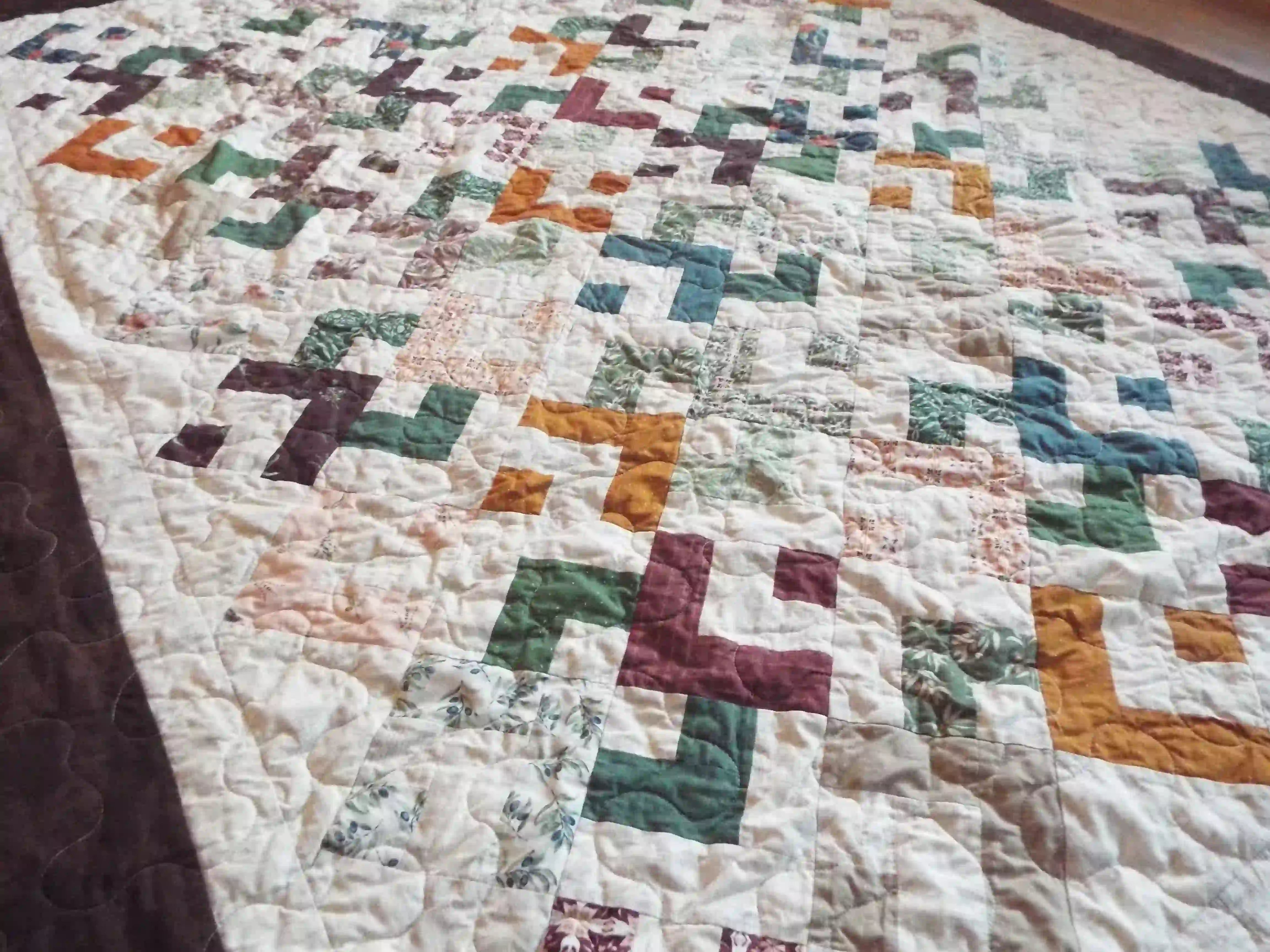 Angled lay of quilt showing stitching and piecing detail