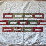 Flat lay of minimal holiday quilt in traditional colors