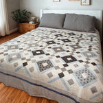 Modern black and white handmade quilt styled in a traditional minimal bedroom