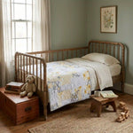 Quilt shown draped over a child's bed