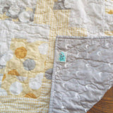 Quilt shown with corner flipped over to show backing fabric and stitching detail