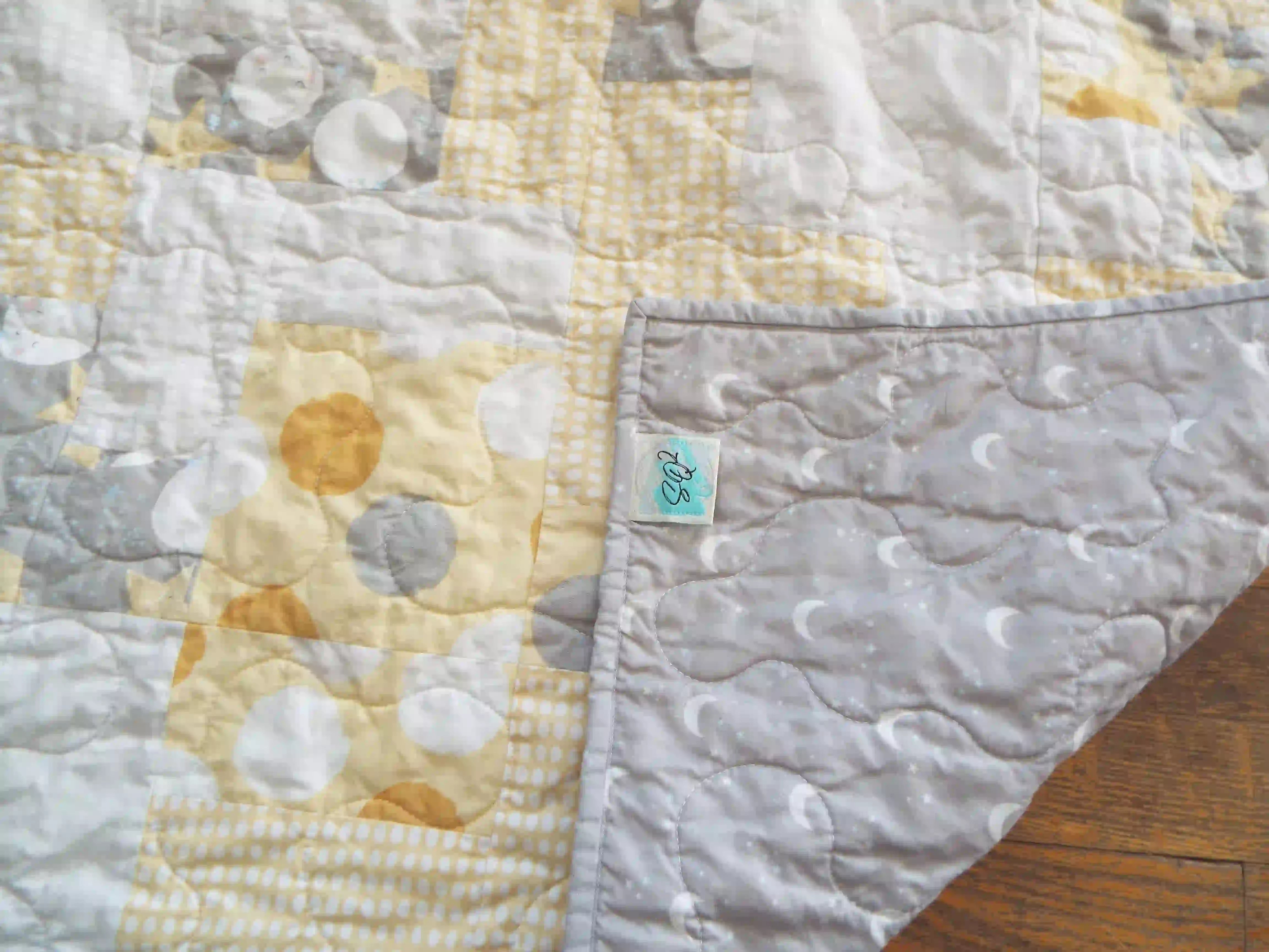 Quilt shown with corner flipped over to show backing fabric and stitching detail