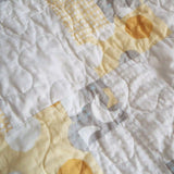 Detail shot of quilt showing stitching and fabrics