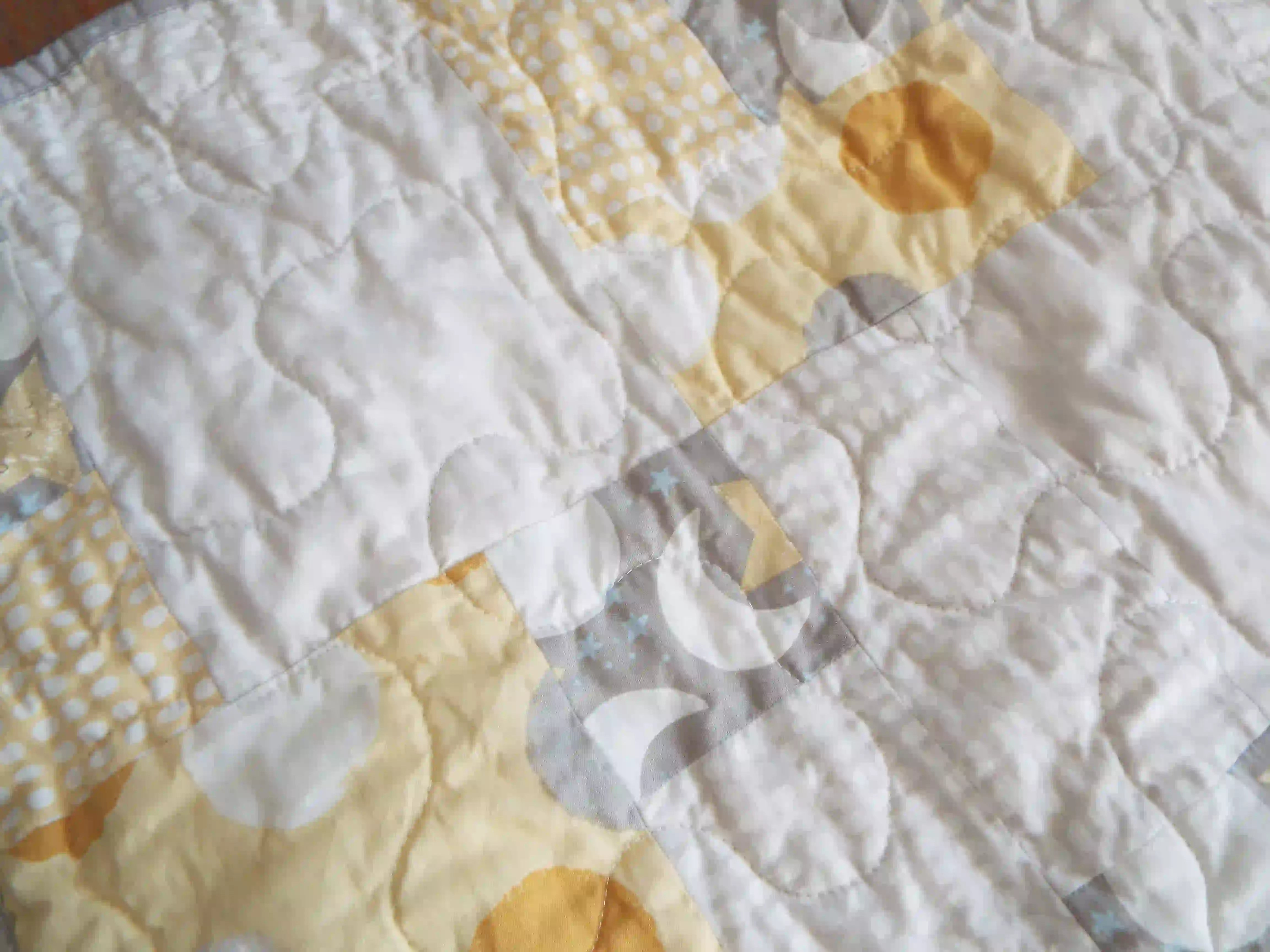 Detail shot of quilt showing stitching and fabrics