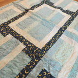 Angled lay of Moonlit Pathways Baby Quilt showing closer look at top.