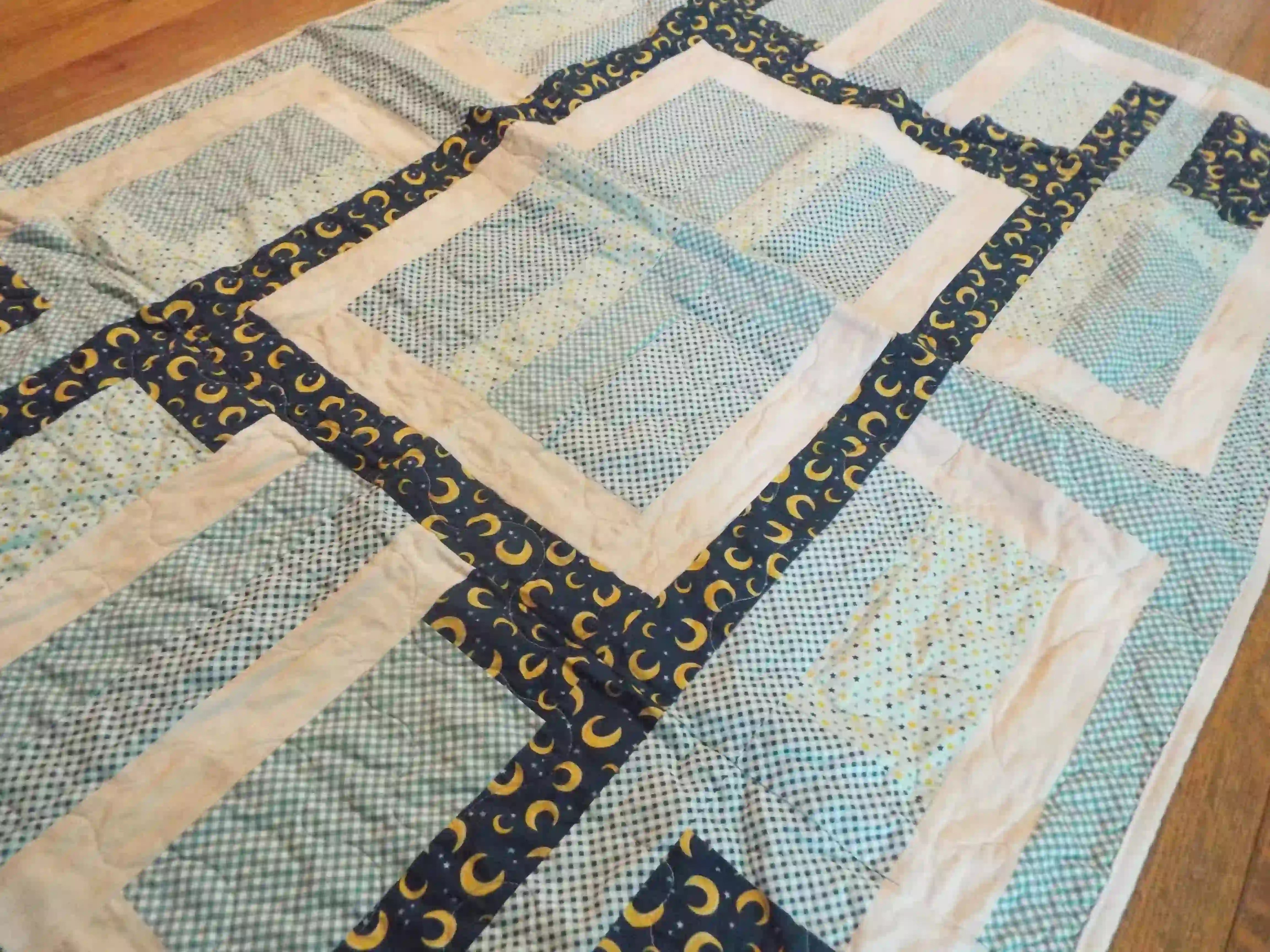 Angled lay of Moonlit Pathways Baby Quilt showing closer look at top.