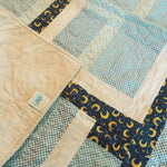 Corner flipped up on Moonlit Pathways Baby Quilt showing backing detail.