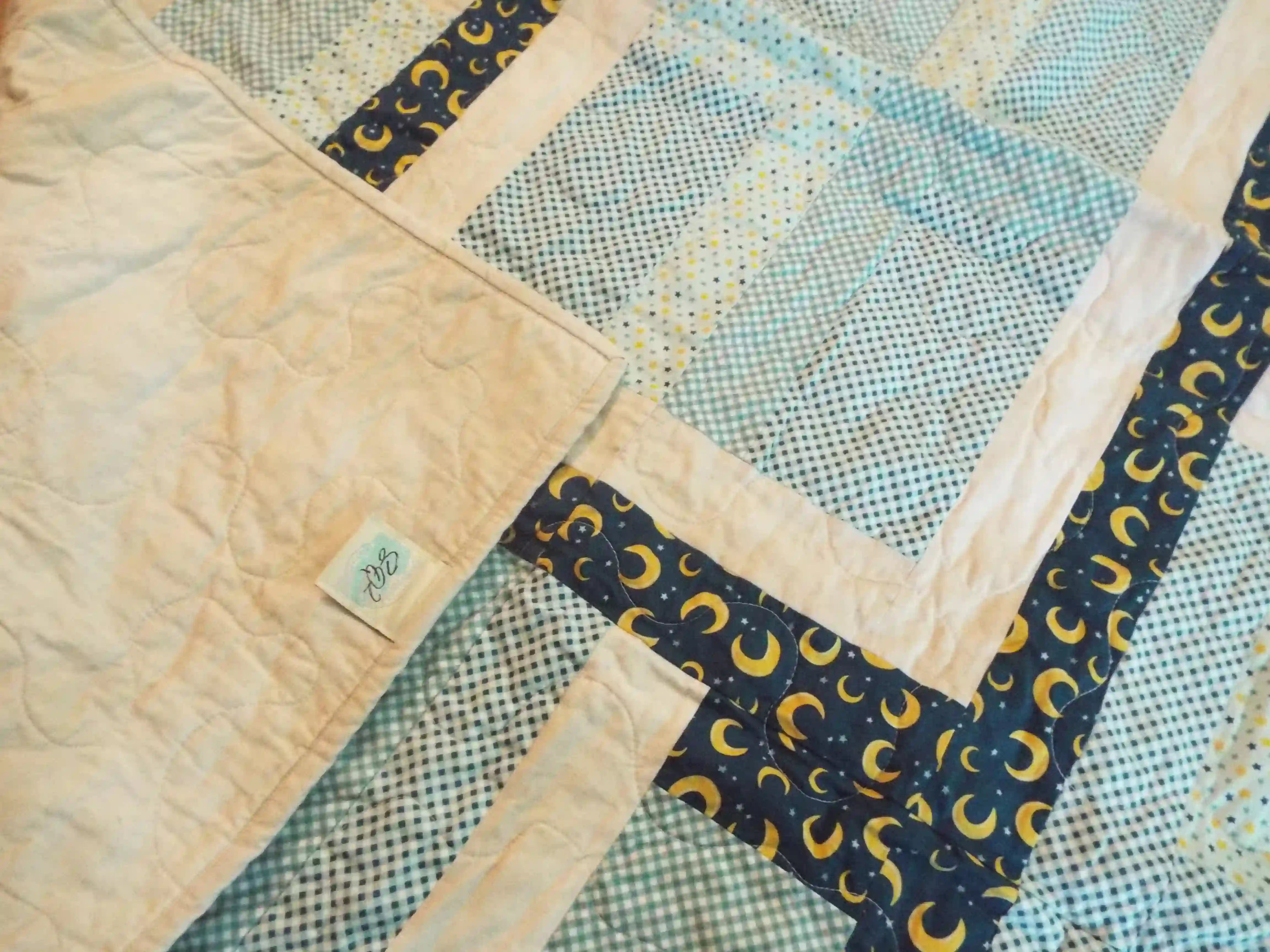 Corner flipped up on Moonlit Pathways Baby Quilt showing backing detail.