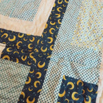 Detail of Moonlit Pathways Baby Quilt showing quilt stitching and fabric.