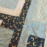 Detail of Moonlit Pathways Baby Quilt showing quilt stitching and fabric.