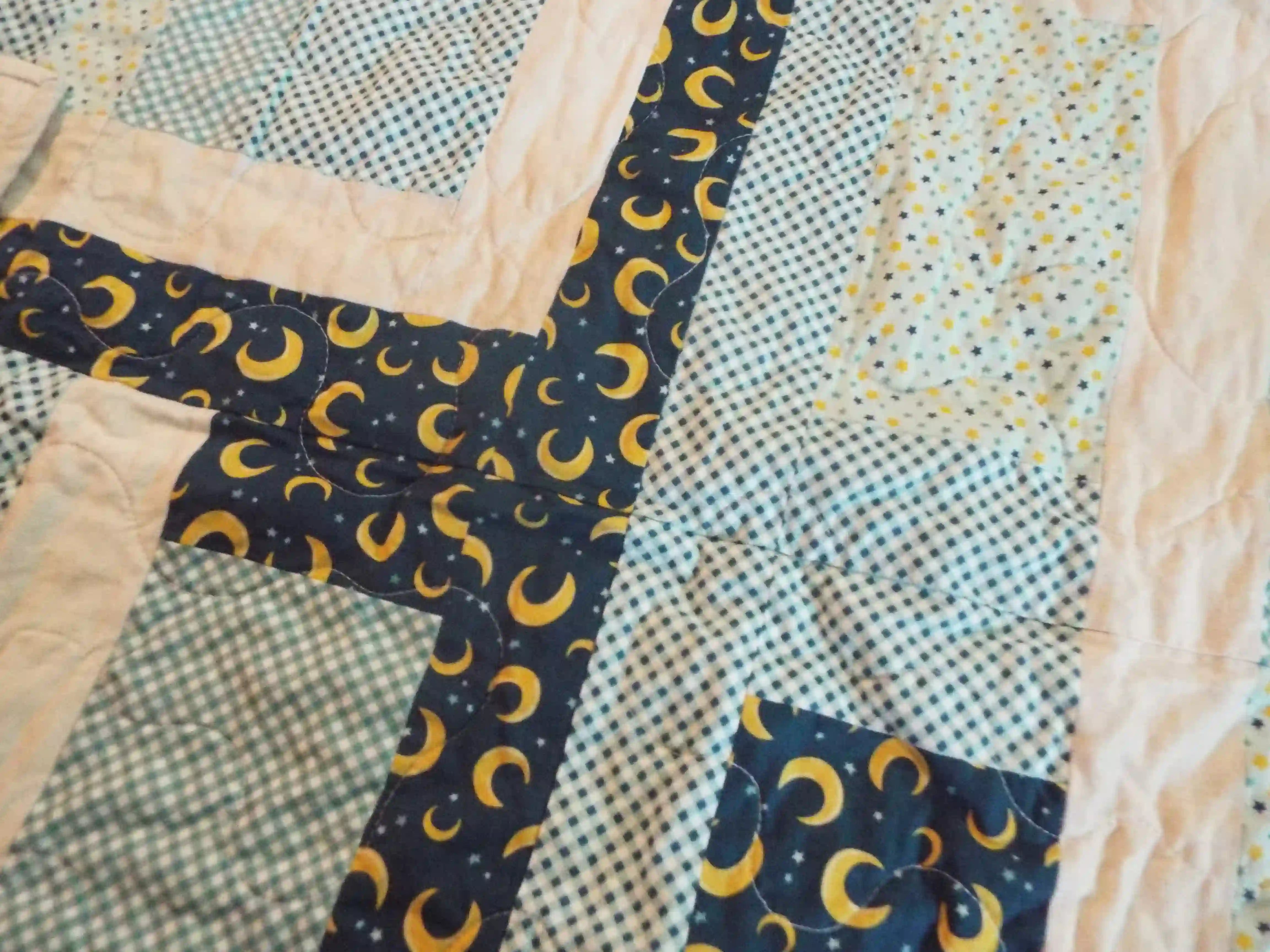 Detail of Moonlit Pathways Baby Quilt showing quilt stitching and fabric.