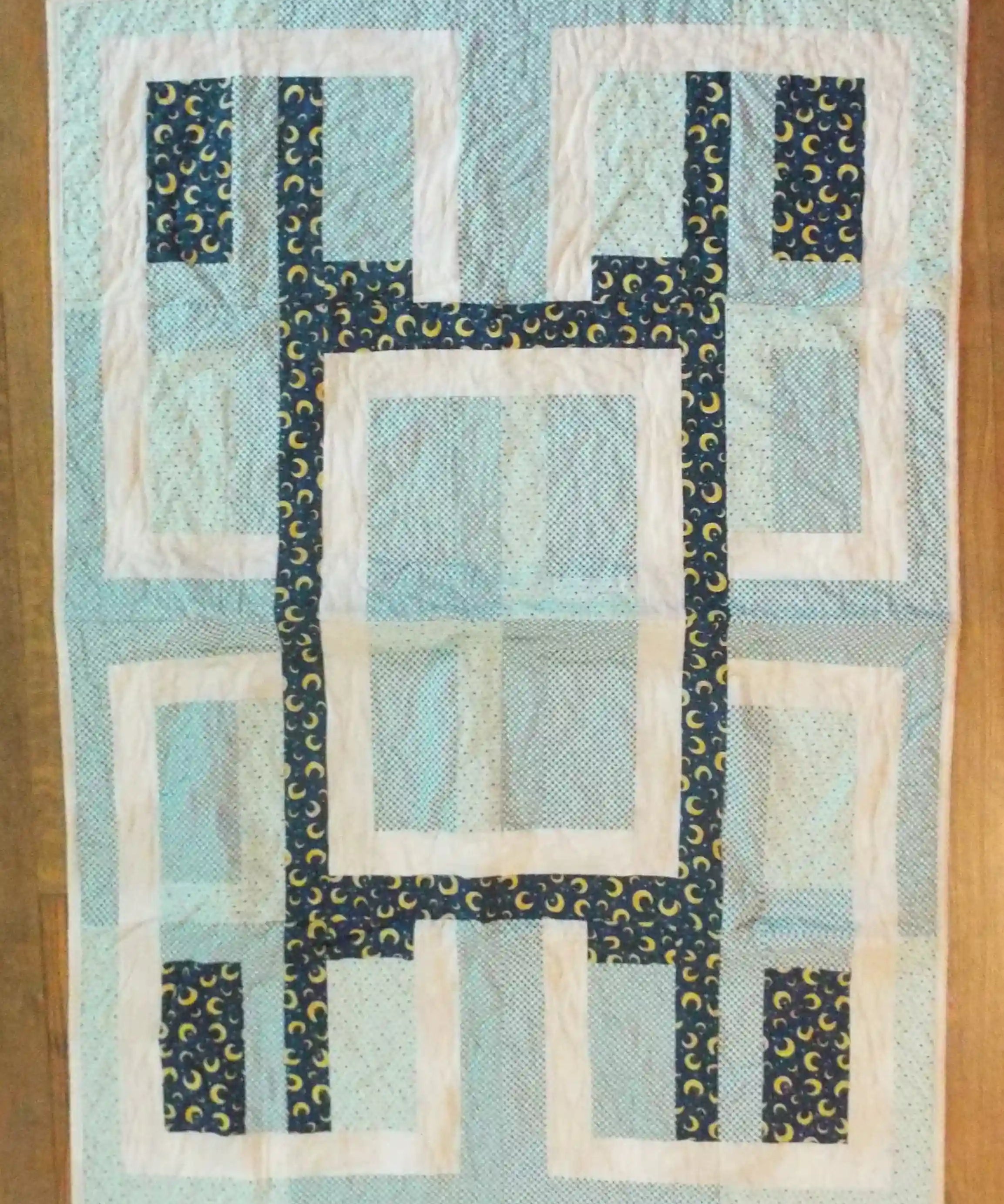 Flat lay of Moonlit Pathways Baby Quilt showing entire quilt.