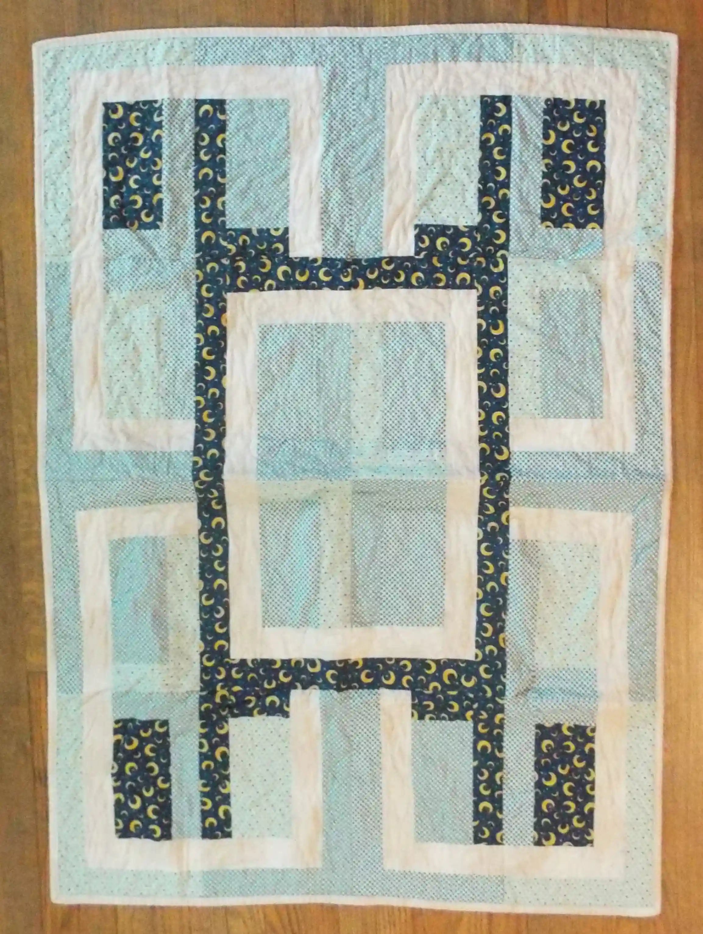 Flat lay of Moonlit Pathways Baby Quilt showing entire quilt.