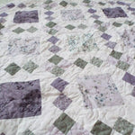 Angled lay of Quiet Meadow showing prints from the quilt