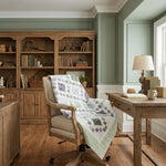 Home office with wooden furniture, bookshelf, and desk where Quiet Meadow is draped over the office chair.