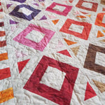 Close up of handmade lap quilt showing stitching detail.