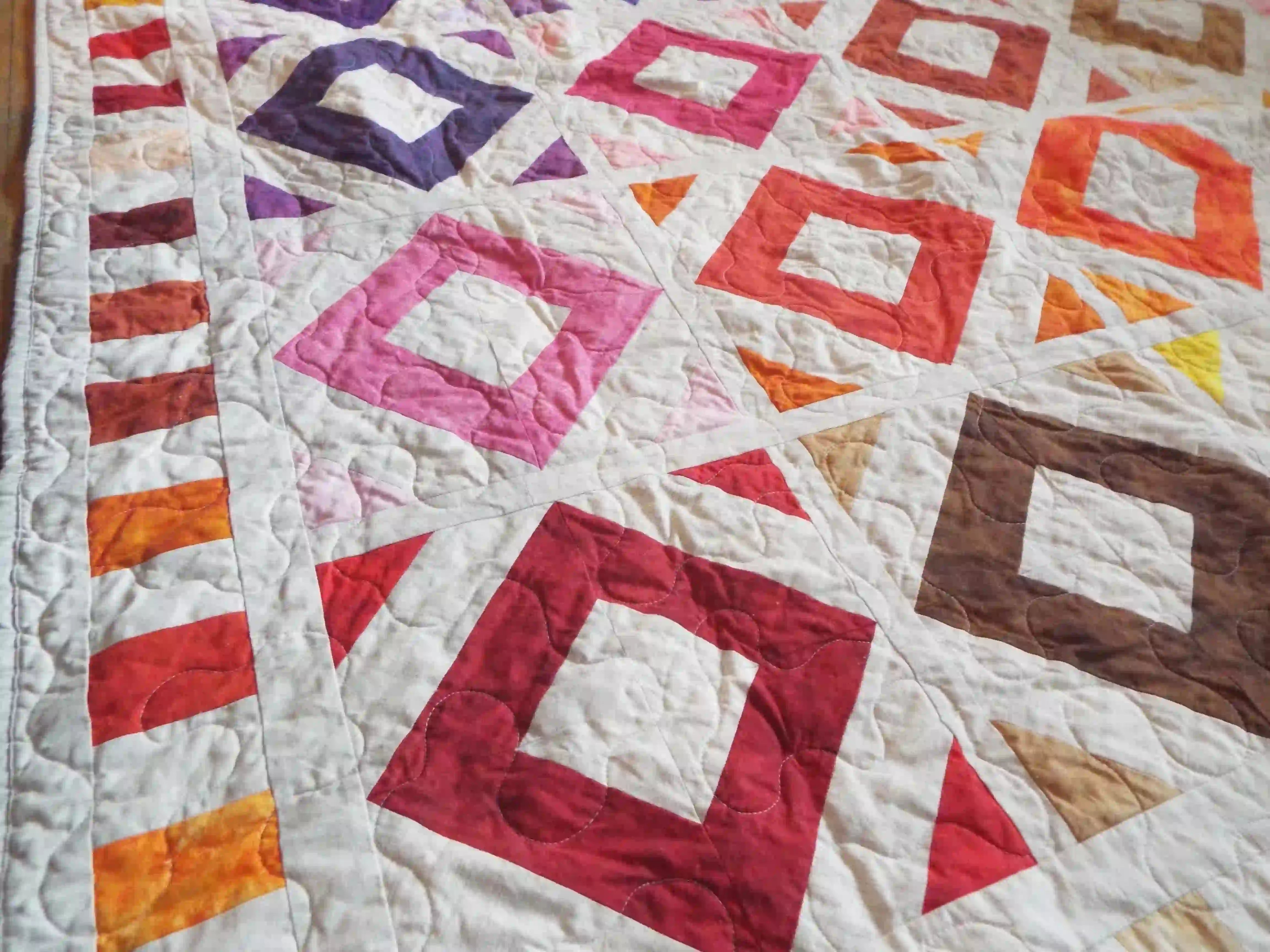 Close up of handmade lap quilt showing stitching detail.